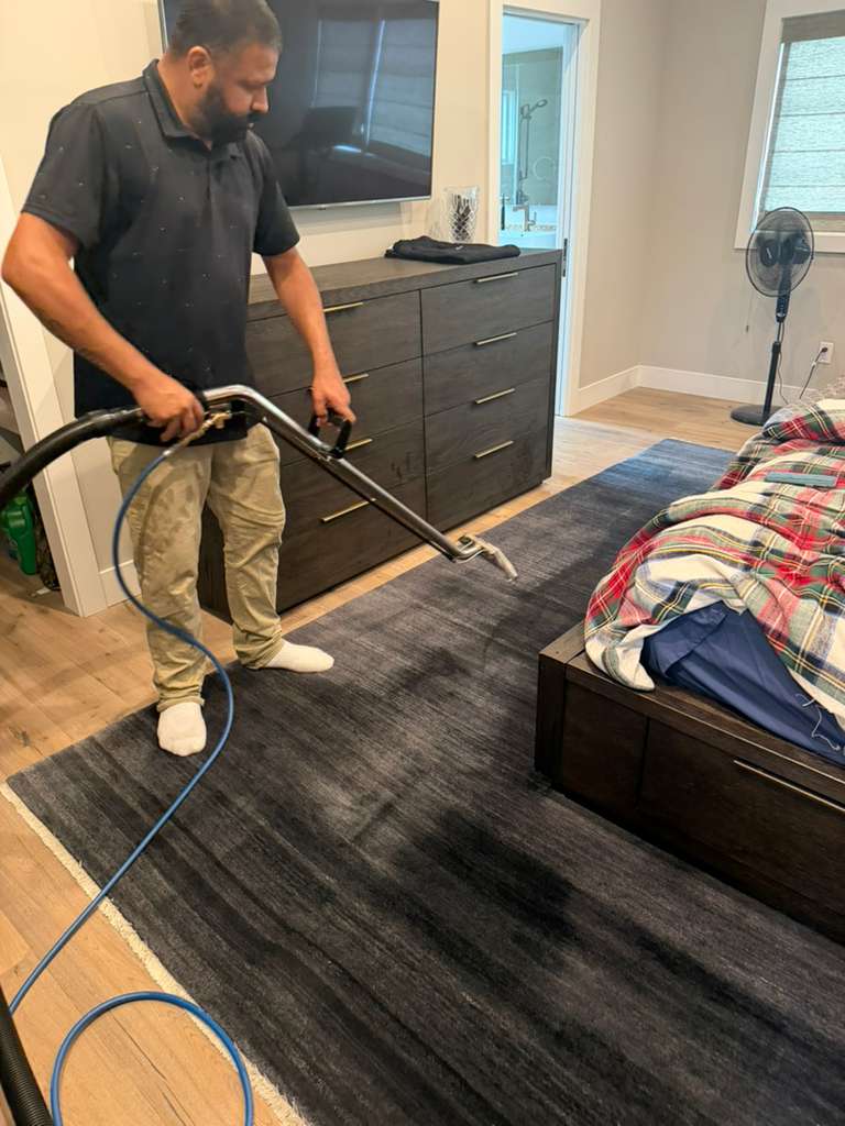 46 Carpet Cleaning technician steam-cleaning a bedroom rug in a Bay Area home